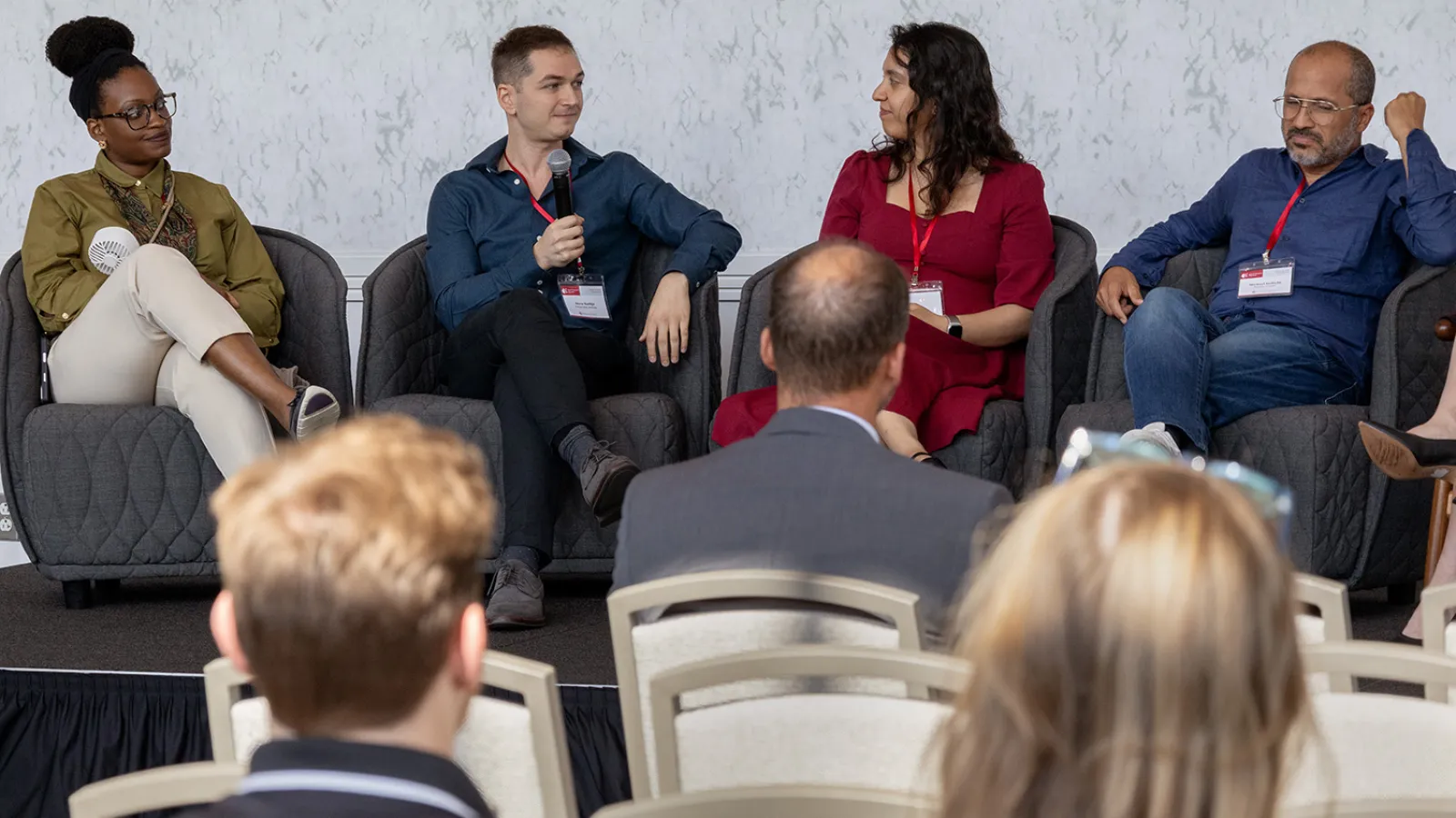 Four people sitting on a stage during a panel session